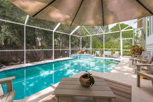 view of swimming pool featuring glass enclosure and a patio area