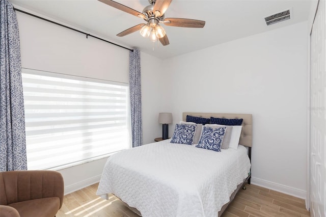 bedroom with light hardwood / wood-style floors and ceiling fan