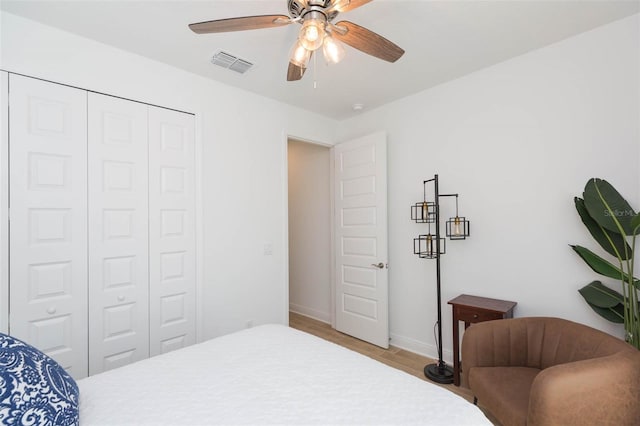 bedroom with ceiling fan, a closet, and light hardwood / wood-style flooring