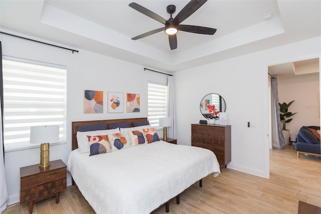 bedroom with a tray ceiling and ceiling fan