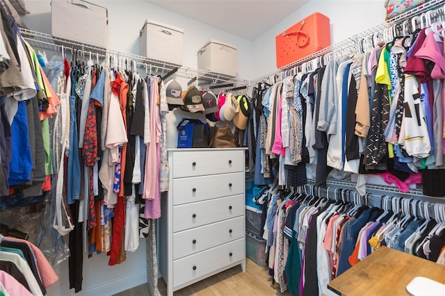 walk in closet with light hardwood / wood-style flooring