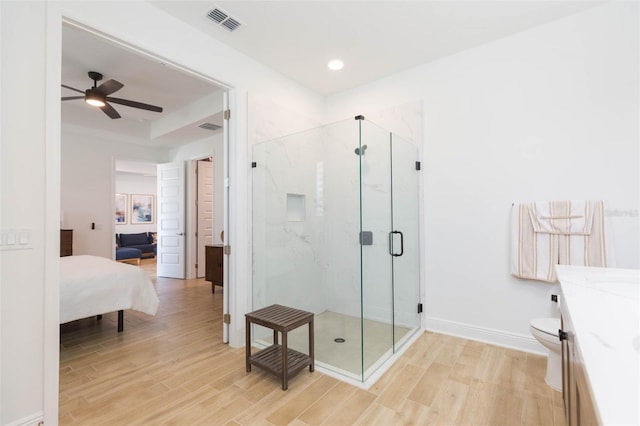 bathroom with vanity, hardwood / wood-style floors, a shower with shower door, and toilet