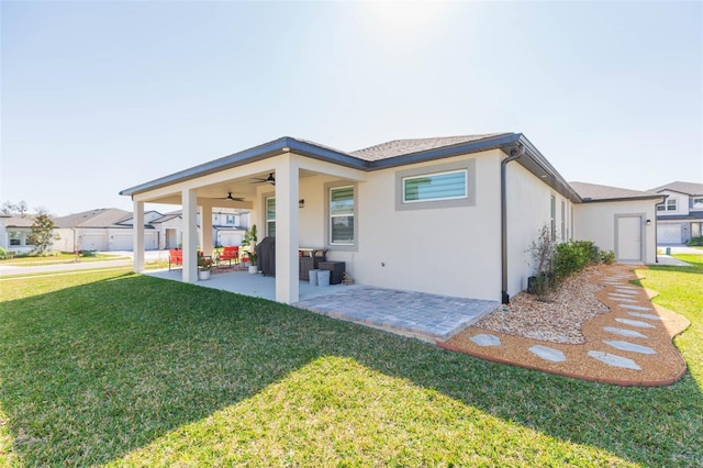 rear view of property featuring a patio area, ceiling fan, and a lawn