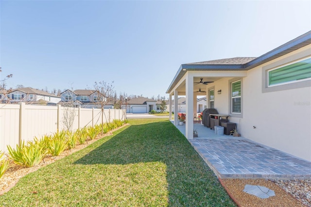 view of yard with ceiling fan and a patio