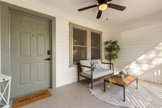 view of exterior entry featuring ceiling fan and covered porch