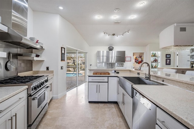 kitchen with sink, wall chimney range hood, stainless steel appliances, decorative backsplash, and vaulted ceiling