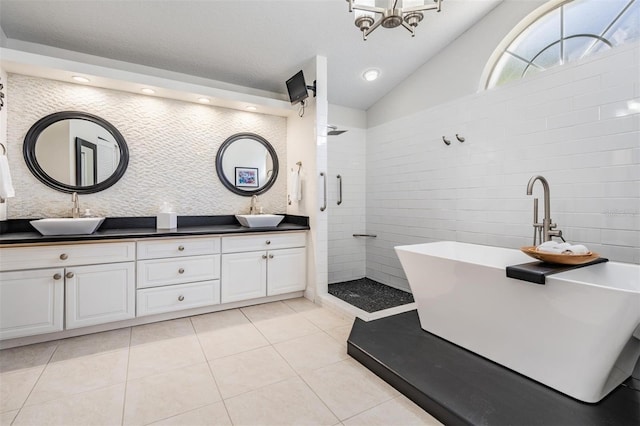 bathroom featuring vanity, lofted ceiling, tile patterned floors, and plus walk in shower