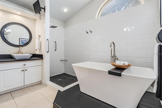 bathroom featuring lofted ceiling, tile patterned floors, separate shower and tub, a textured ceiling, and vanity