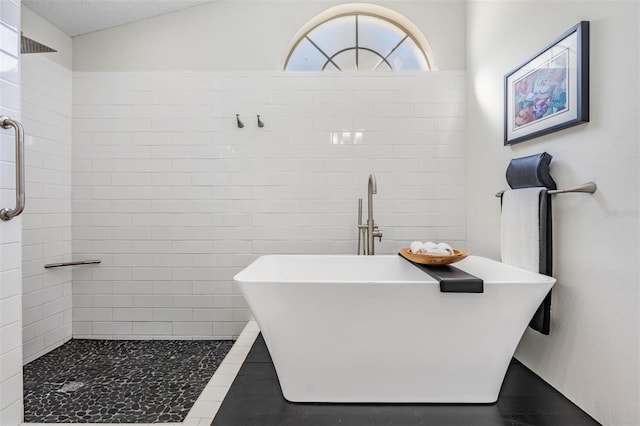 bathroom featuring a textured ceiling and separate shower and tub