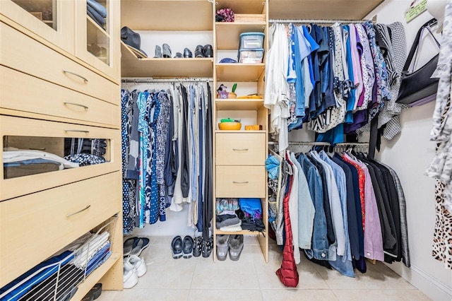 walk in closet with light tile patterned floors