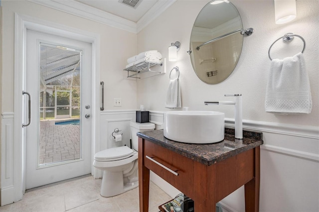 bathroom featuring a shower, tile patterned flooring, vanity, toilet, and crown molding