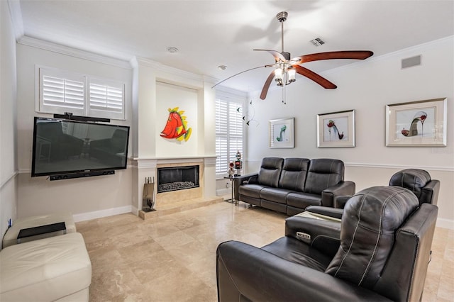 living room with a premium fireplace, ornamental molding, and ceiling fan