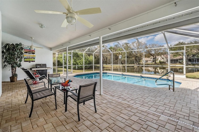 view of swimming pool with a water view, glass enclosure, and a patio area