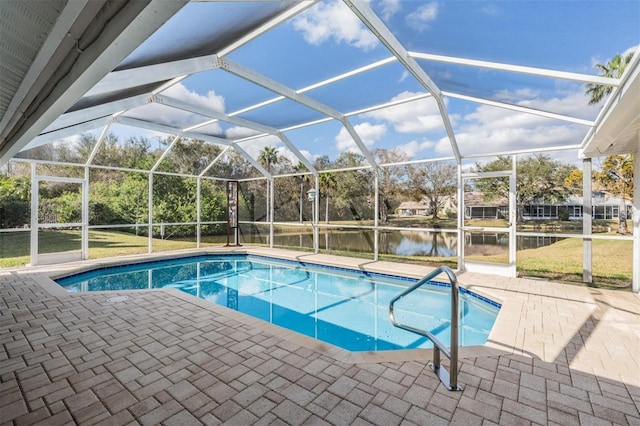 view of pool featuring a patio area, a water view, and glass enclosure