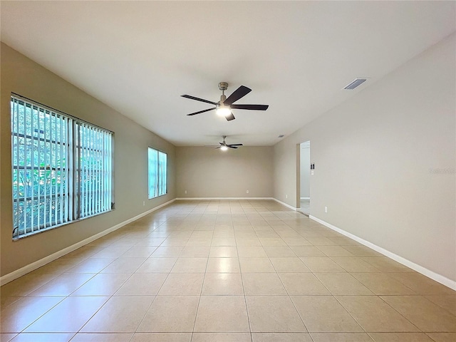 tiled empty room featuring ceiling fan