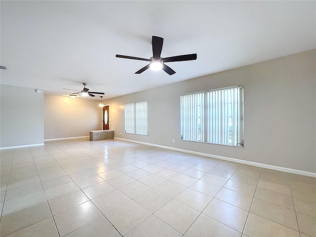 tiled spare room featuring ceiling fan