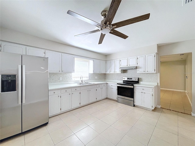 kitchen with appliances with stainless steel finishes, sink, white cabinets, decorative backsplash, and light tile patterned floors