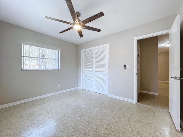 unfurnished bedroom with ceiling fan and a closet