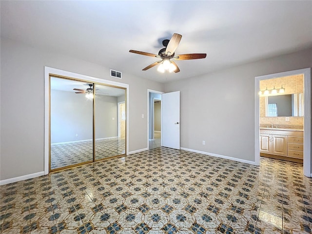 unfurnished bedroom with connected bathroom, sink, a closet, and ceiling fan