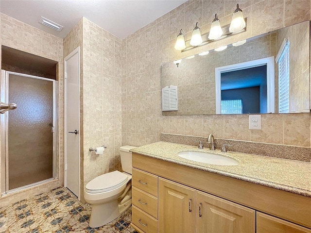 bathroom featuring vanity, toilet, an enclosed shower, and tile walls