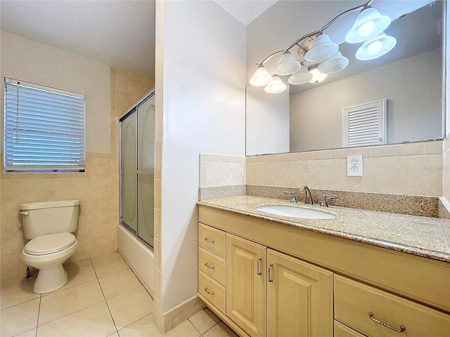 full bathroom featuring vanity, tile walls, tile patterned floors, and toilet