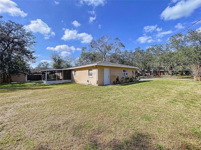 back of house with a sunroom and a yard