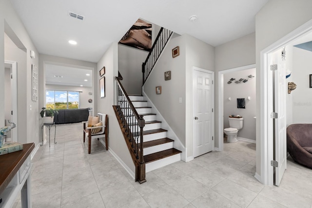 stairway with tile patterned floors