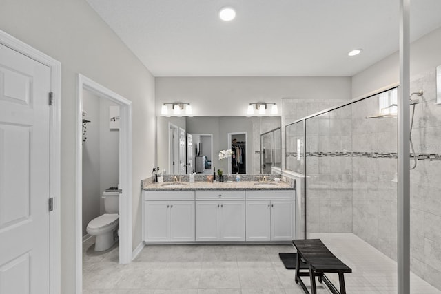 bathroom featuring tiled shower, vanity, toilet, and tile patterned floors