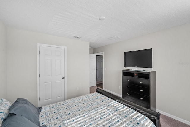 bedroom with dark carpet and a textured ceiling