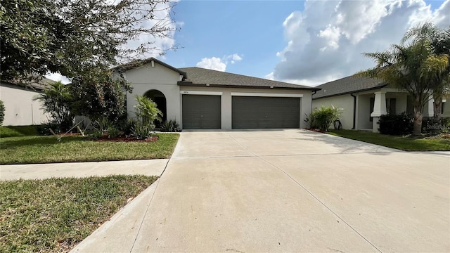 view of front of property featuring driveway, a front lawn, an attached garage, and stucco siding