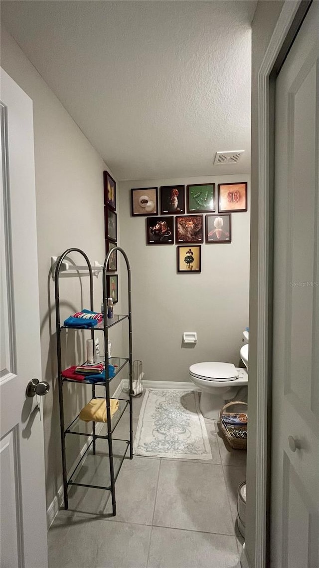 10854 Sage Canyon Dr, Riverview, FL 33578 - bathroom with visible vents, toilet, a textured ceiling, baseboards, and tile patterned floors