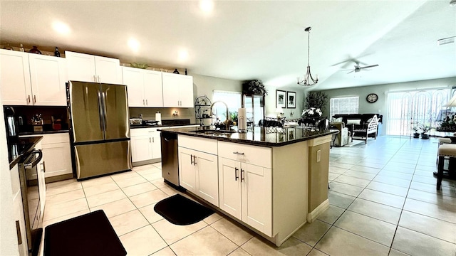 10854 Sage Canyon Dr, Riverview, FL 33578 - kitchen featuring light tile patterned floors, dark countertops, appliances with stainless steel finishes, white cabinetry, and a sink