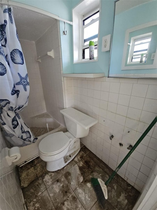 bathroom with a wealth of natural light, toilet, tile walls, and a shower with curtain