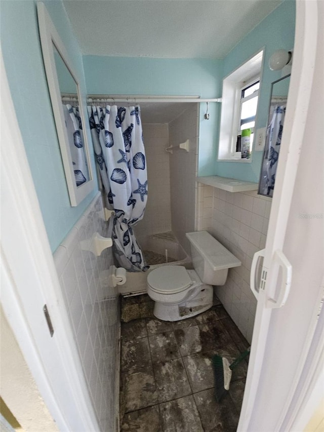 bathroom featuring toilet, tile walls, and a shower with curtain