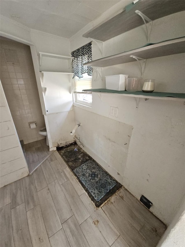 interior space featuring crown molding and toilet