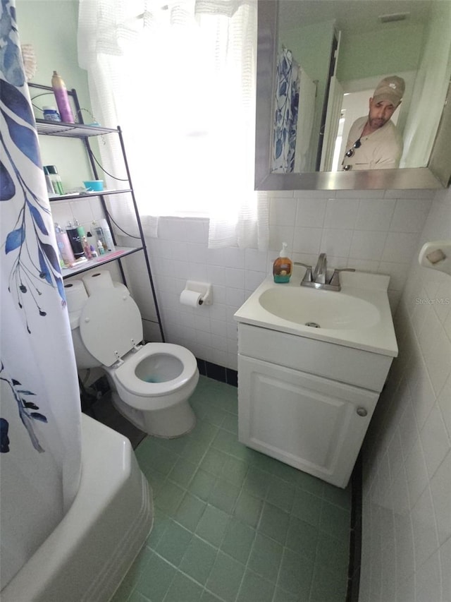 full bathroom with shower / bath combo, tile walls, vanity, tile patterned floors, and toilet