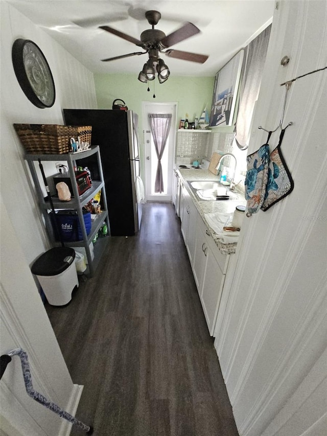 kitchen featuring stainless steel refrigerator, white cabinetry, sink, dark hardwood / wood-style flooring, and ceiling fan