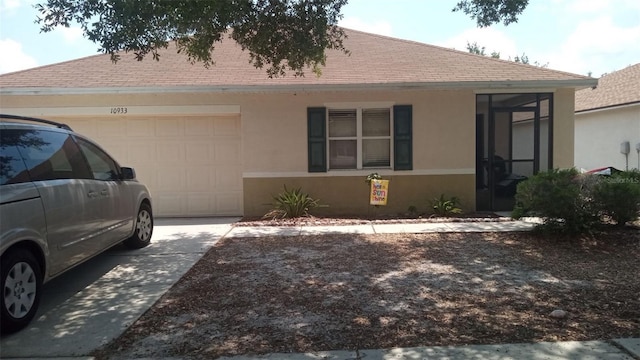 view of front facade featuring driveway, an attached garage, roof with shingles, and stucco siding