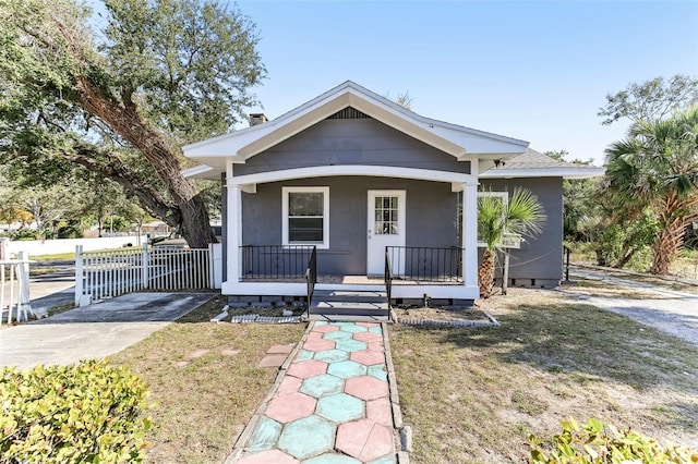 bungalow-style home featuring a porch and a front yard