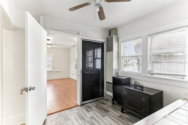 bedroom with ornamental molding, ceiling fan, and light wood-type flooring