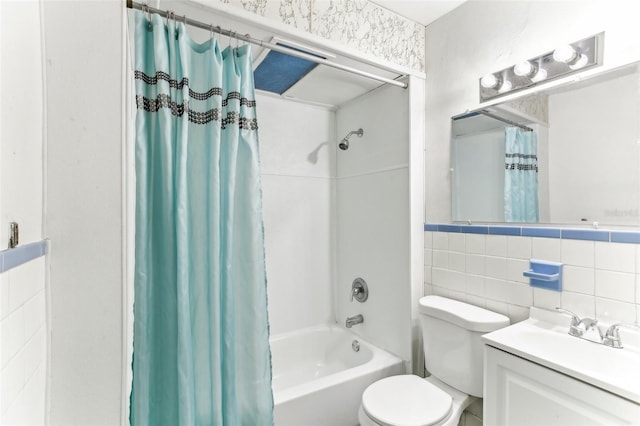 full bathroom featuring shower / bath combination with curtain, vanity, toilet, and tile walls