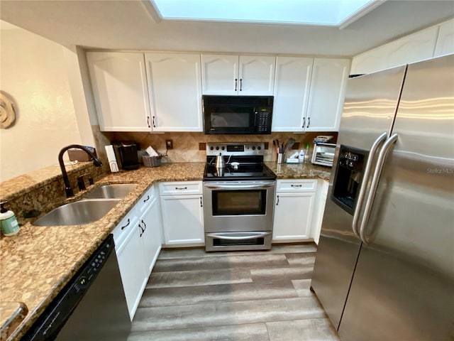 kitchen featuring stone counters, white cabinetry, sink, backsplash, and stainless steel appliances