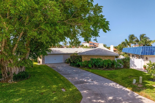 single story home featuring a garage and a front yard