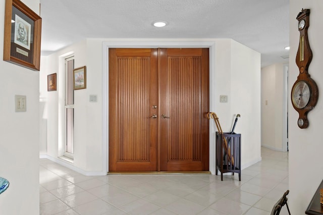 entrance foyer with light tile patterned floors and a textured ceiling