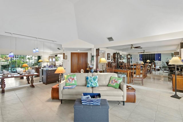 tiled living room featuring a towering ceiling, track lighting, and ceiling fan