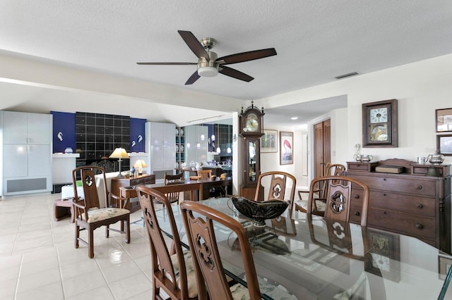 tiled dining room featuring ceiling fan and a textured ceiling