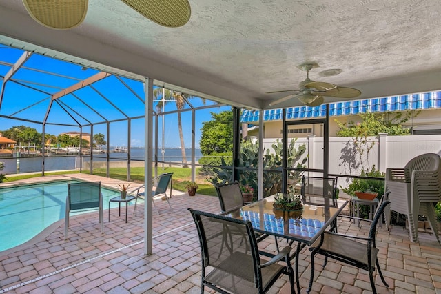 view of patio with a fenced in pool, a lanai, ceiling fan, and a water view