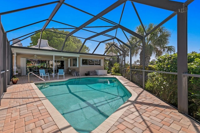 view of swimming pool featuring a lanai, ceiling fan, and a patio area