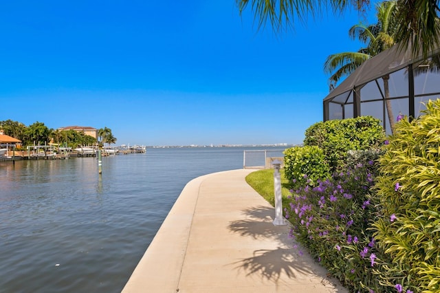 exterior space featuring a water view and glass enclosure