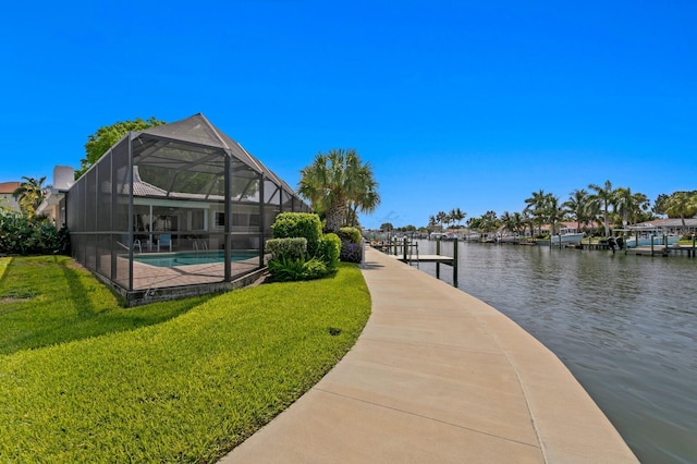 dock area featuring a lawn, a water view, and glass enclosure